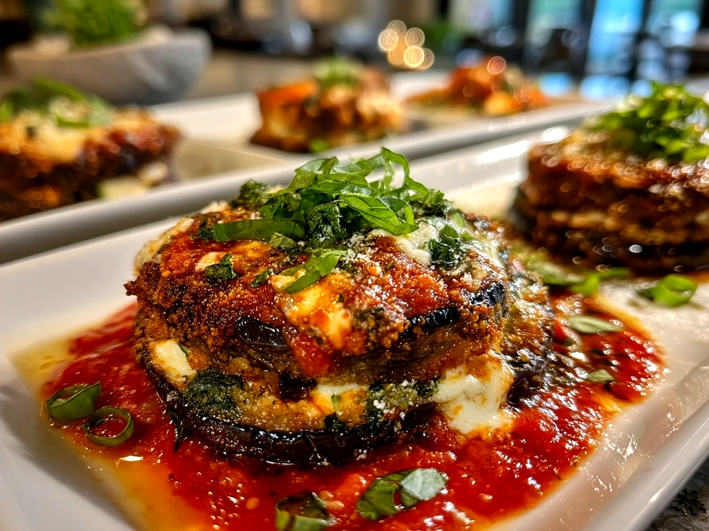 Final serving of Eggplant Parmesan Stacks garnished with fresh basil leaves